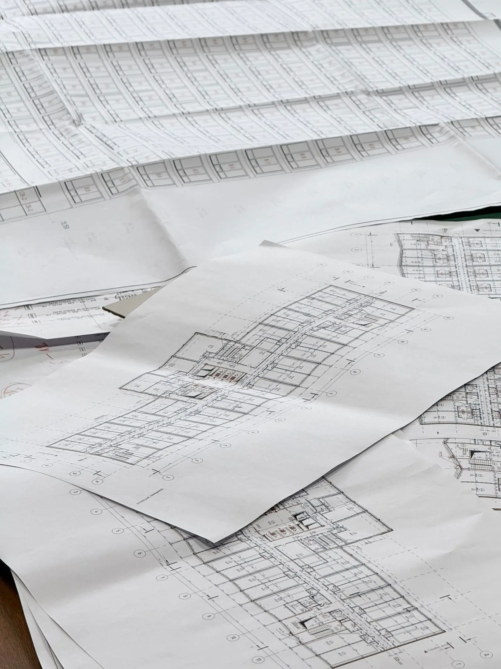 Planos arquitectónicos extendidos sobre una mesa de proyecto
