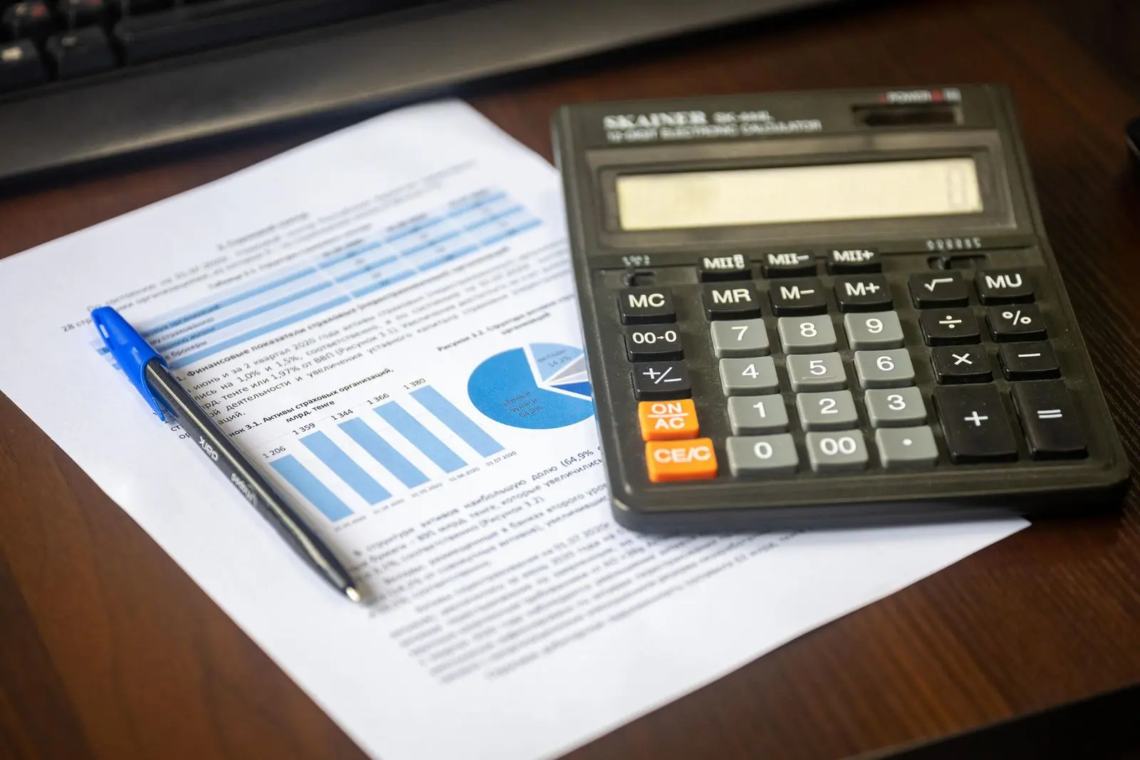Calculadora y reporte financiero dispuestos sobre un escritorio
