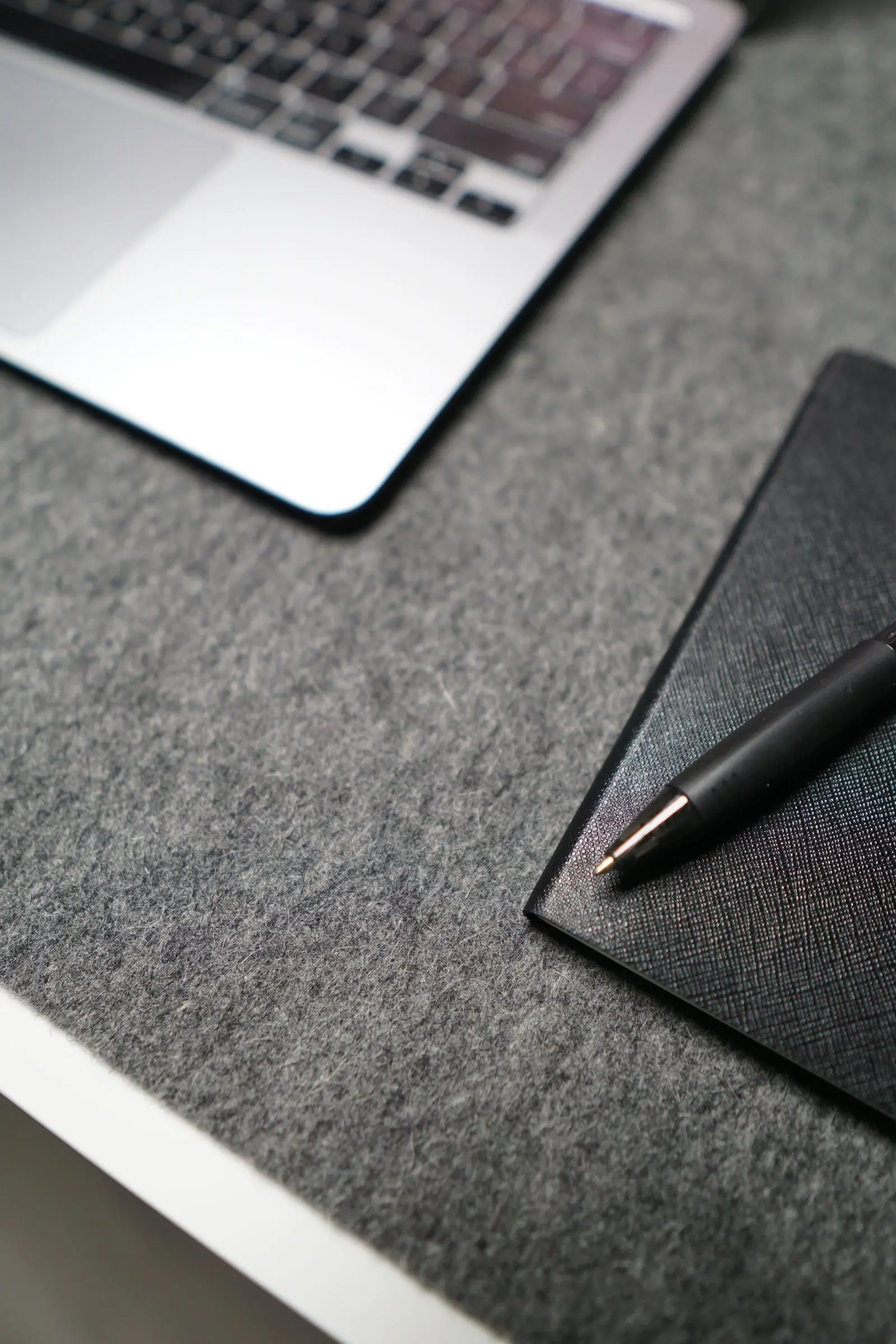 Cuaderno y computadora portátil sobre una superficie sobria